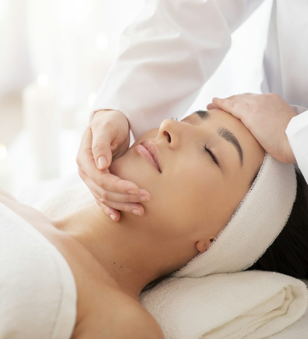 Masseuse Lady Making Face Lifting Massage To Indian Woman In Spa Salon