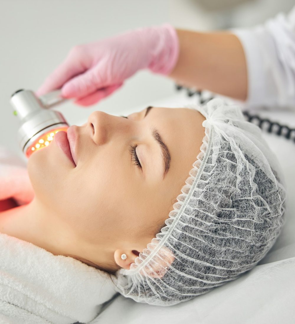 Relaxed dark-haired patient undergoing a skin treatment